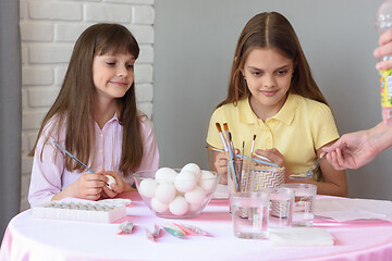 Image showing Mom prepares a solution for painting eggs, children are watching with curiosity