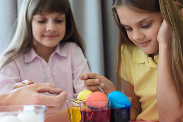 Image showing Children paint chicken eggs in different colors.