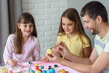 Image showing Dad shows children how to easily and easily paint Easter eggs