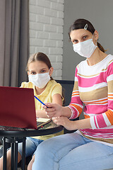 Image showing Portrait of a family in front of a laptop screen in medical masks