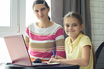 Image showing Happy girl doing homework with mom looked in frame