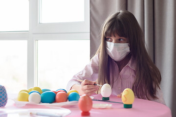 Image showing The sick girl alone paints Easter eggs for the holiday