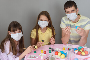 Image showing Dad and two quarantined girls paint Easter eggs
