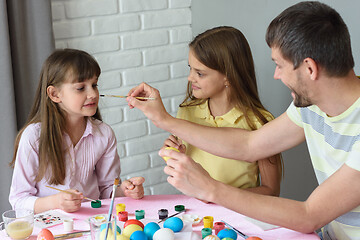 Image showing Dad paints his nose for daughter while painting Easter eggs