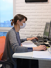 Image showing A sick quarantined girl works at a computer