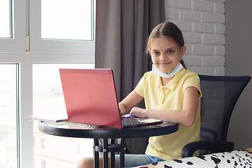 Image showing Girl at home at the table doing homework online