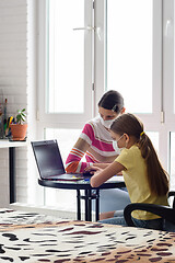 Image showing Self-isolation, mom and daughter study at school online via the Internet