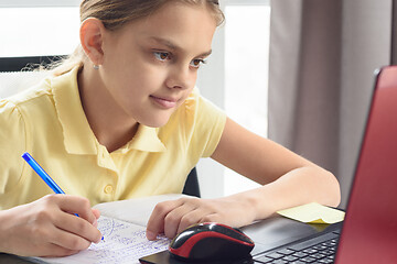 Image showing Portrait of a cute girl at the laptop engaged in distance learning