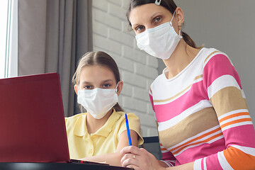 Image showing Mom and daughter in medical masks quarantined study online