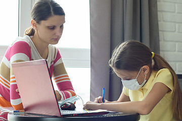 Image showing Mom helps to do homework for a sick child through distance learning