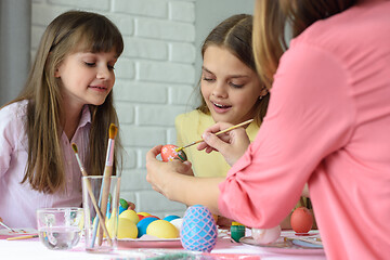 Image showing Mom shows girls how to paint Easter eggs beautifully