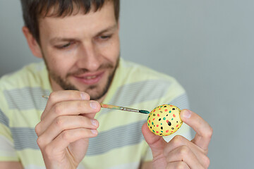 Image showing Man paints an egg for Easter