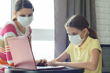 Image showing Girl does homework online, mom is watching nearby