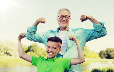 Image showing happy grandfather and grandson showing muscles