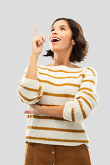 Image showing woman in striped pullover pointing her finger up
