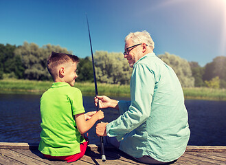 Image showing grandfather and grandson fishing on river berth