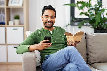 Image showing smiling indian man eating takeaway food at home