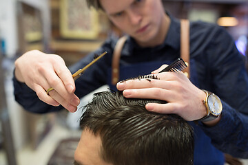 Image showing male hairdresser cutting hair at barbershop