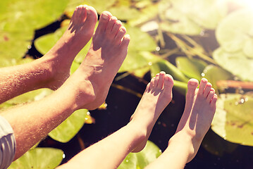 Image showing grandfather and grandson feet over river