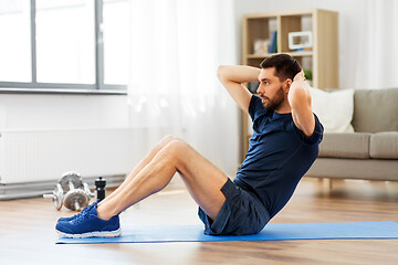 Image showing man making abdominal exercises at home