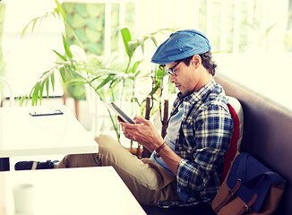 Image showing man with tablet pc sitting at cafe table