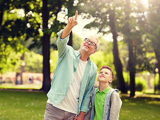 Image showing grandfather and boy pointing up at summer park