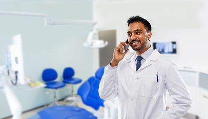 Image showing dentist calling on smartphone at dental clinic