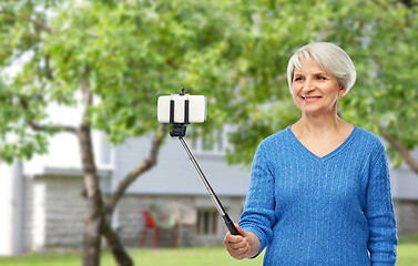 Image showing smiling senior woman taking selfie by smartphone