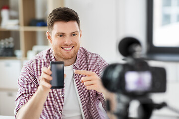 Image showing male blogger with smartphone videoblogging at home