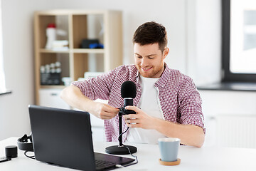 Image showing male audio blogger connecting cable to microphone