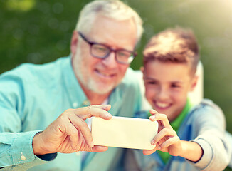 Image showing old man and boy taking selfie by smartphone