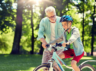 Image showing grandfather and boy with bicycle at summer park