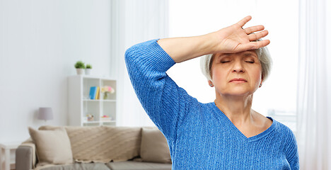 Image showing tired senior woman suffering from headache