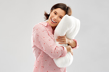 Image showing happy young woman in pajama hugging pillow