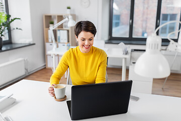 Image showing businesswoman with laptop drinks coffee at office