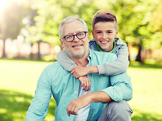 Image showing grandfather and grandson hugging at summer park