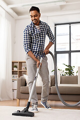 Image showing indian man with vacuum cleaner at home