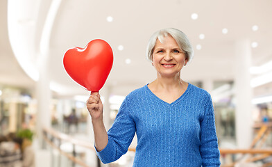 Image showing smiling senior woman with red heart shaped balloon