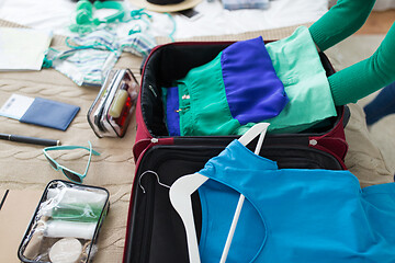 Image showing woman packing travel bag at home or hotel room