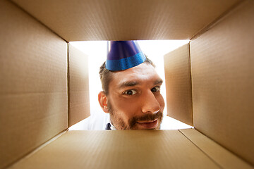 Image showing happy man opening parcel box or birthday gift