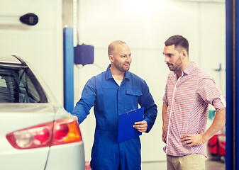 Image showing auto mechanic with clipboard and man at car shop