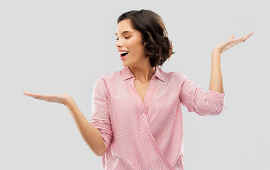 Image showing young woman in striped shirt holding something