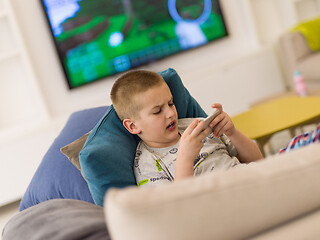 Image showing little boy playing games on smartphone