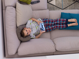 Image showing top view of  little boy playing games on tablet computers