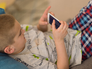 Image showing little boy playing games on smartphone