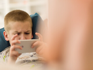 Image showing little boy playing games on smartphone