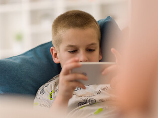 Image showing little boy playing games on smartphone