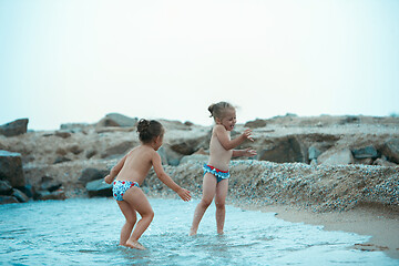 Image showing Two happy children playing on the beach at the day time