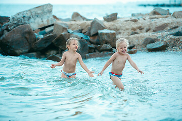 Image showing Two happy children playing on the beach at the day time