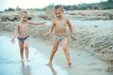 Image showing Two happy children playing on the beach at the day time